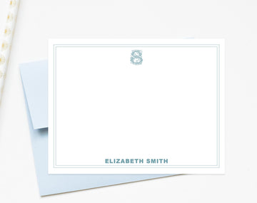 A blank white card with a blue border, featuring a monogrammed letter 'S' and the name 'ELIZABETH SMITH' printed on it.