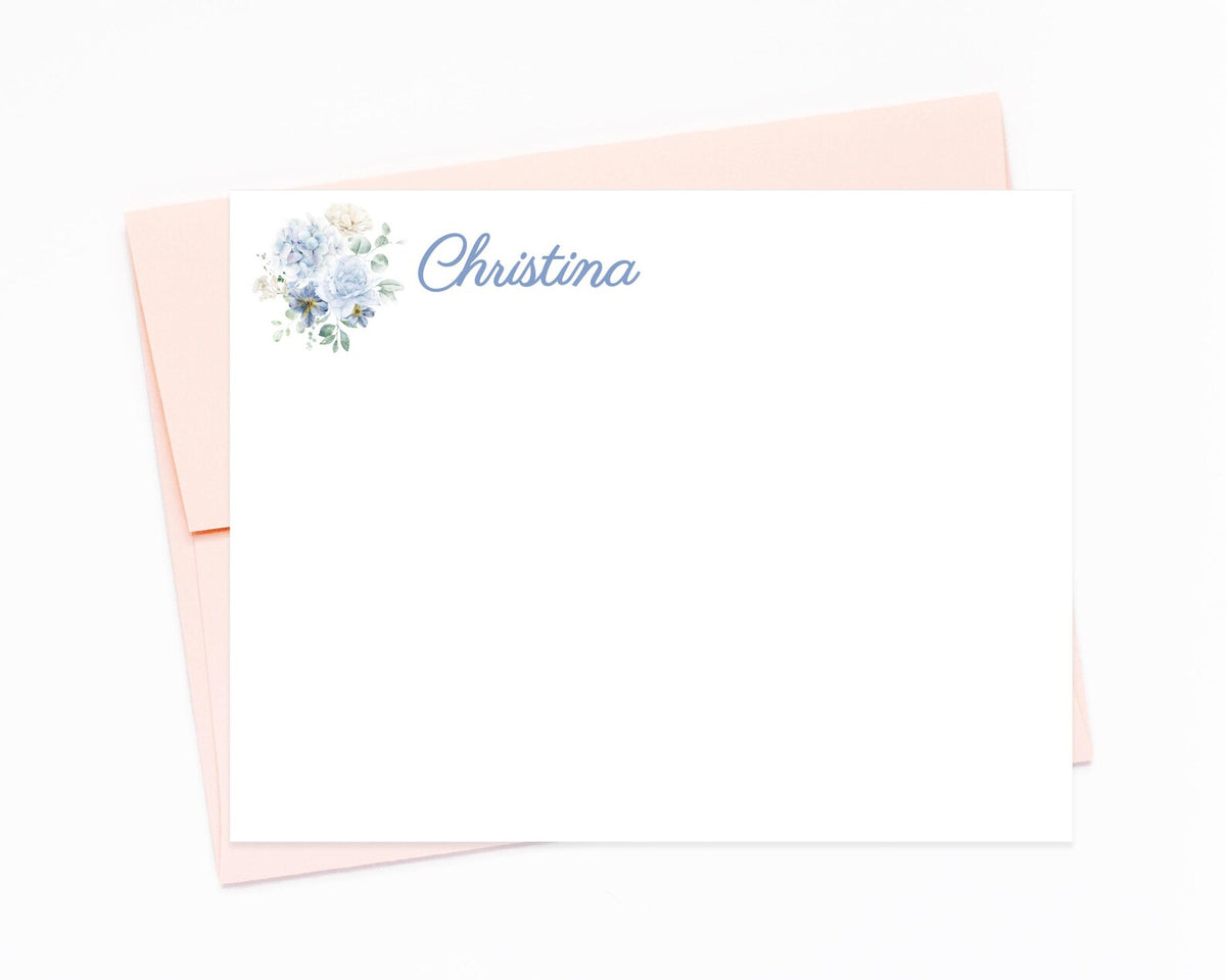 a blank card with a floral design and the name "Christina" written on it, placed on top of an envelope.