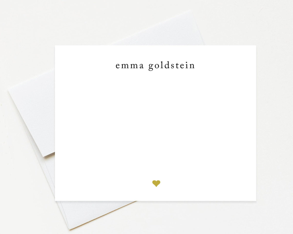 A white card with the name 'Emma Goldstein' printed on it, along with a small gold heart symbol.