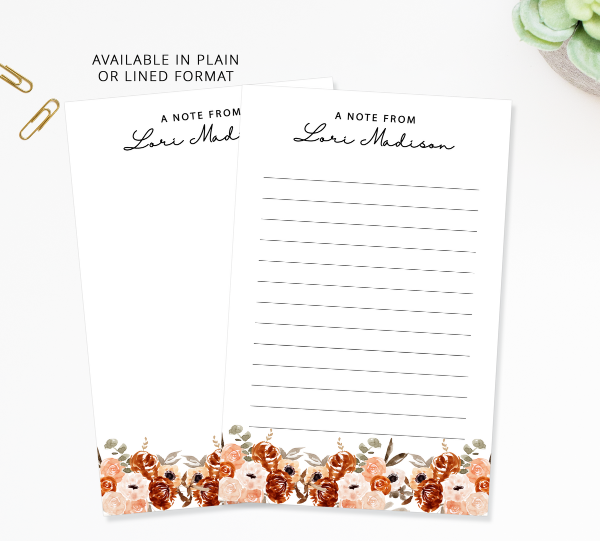 two blank lined notepads with a floral border, placed on a white surface.