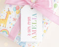 A gift wrapped in a colorful paper with a pink ribbon and a tag that says 