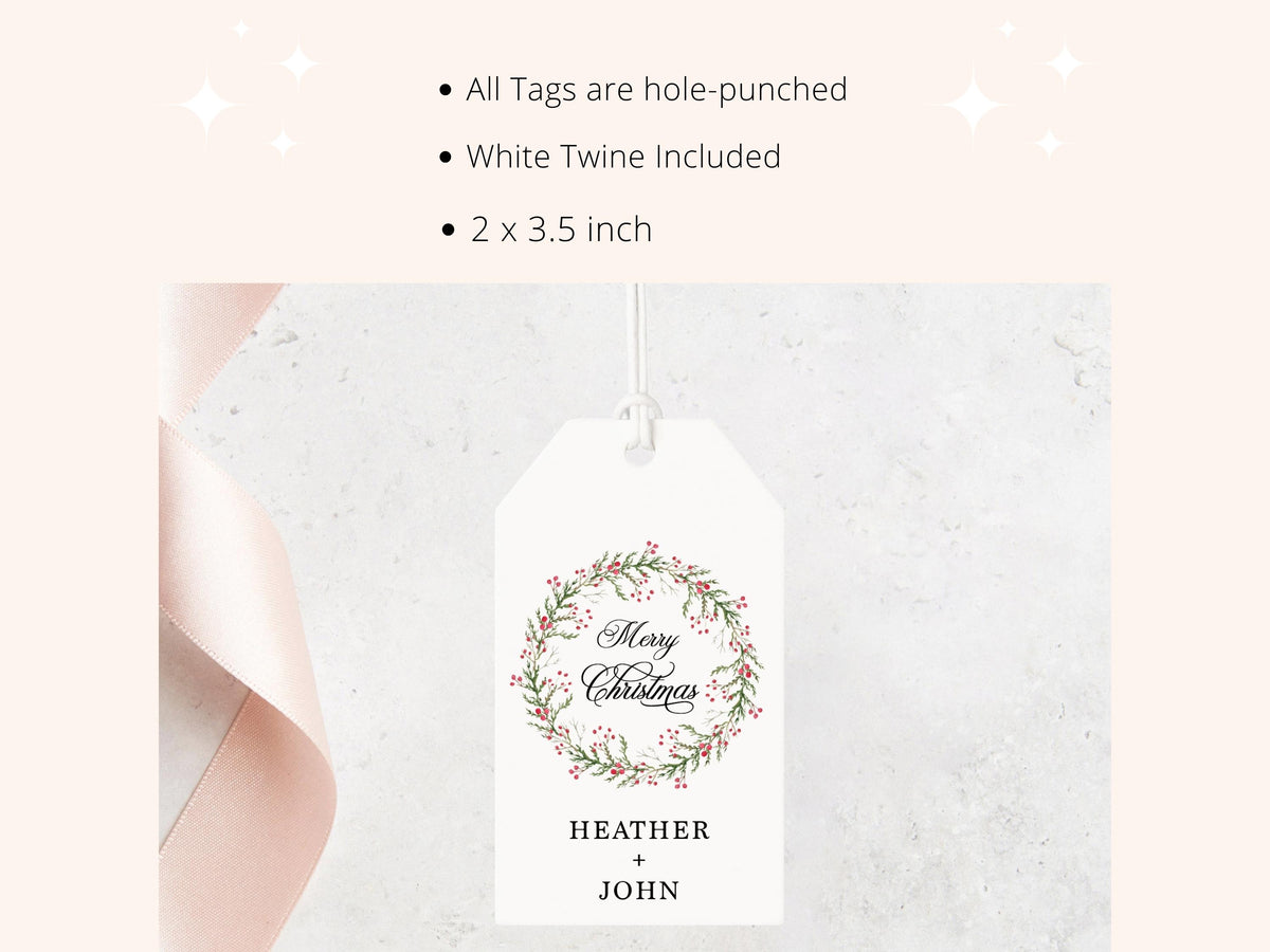 a white Christmas tag with a wreath design and the text "Merry Christmas" written on it. The tag is hanging from a string, and there is a ribbon visible on the left side of the image.