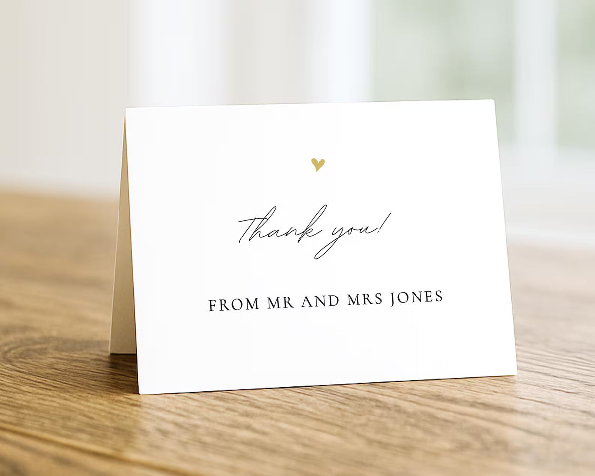 A white card with a gold heart and the text "Thank you! From Mr and Mrs Jones" is placed on a wooden surface.