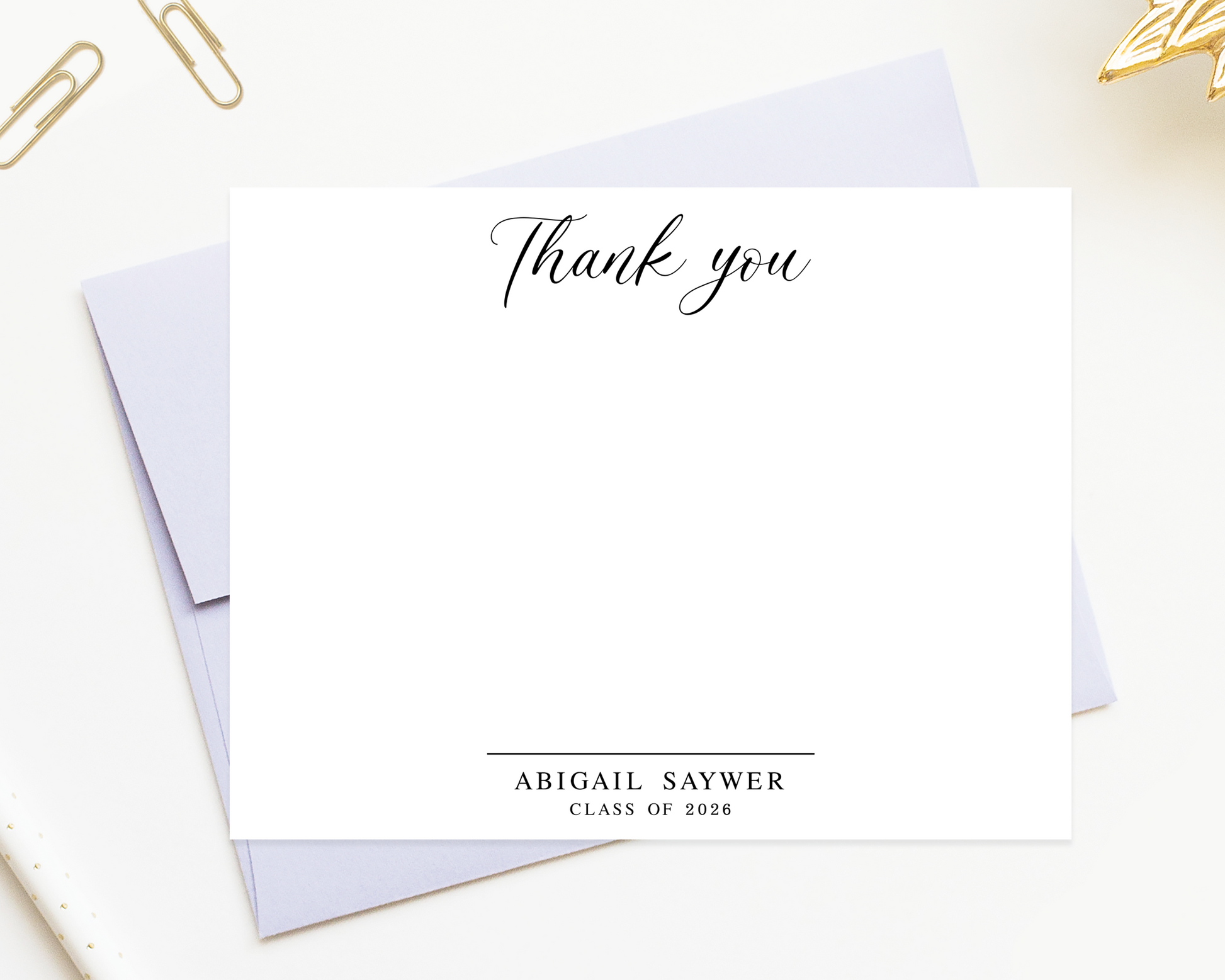 a blank thank you card with a personalized message, placed on a white surface alongside some office supplies.