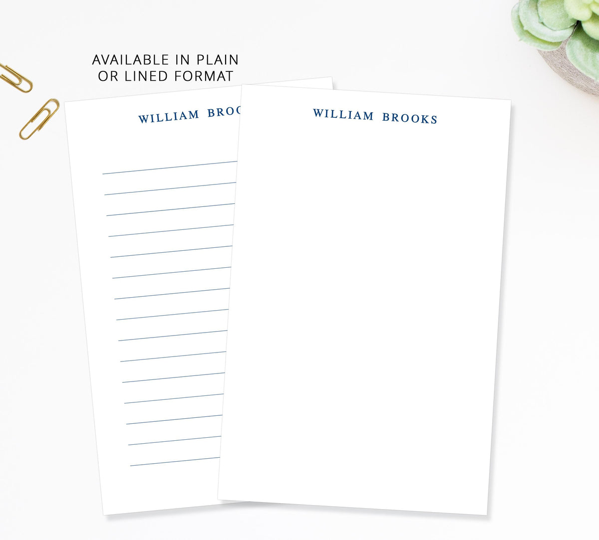 two blank lined paper pads with the name 'William Brooks' printed on them, placed on a white surface.