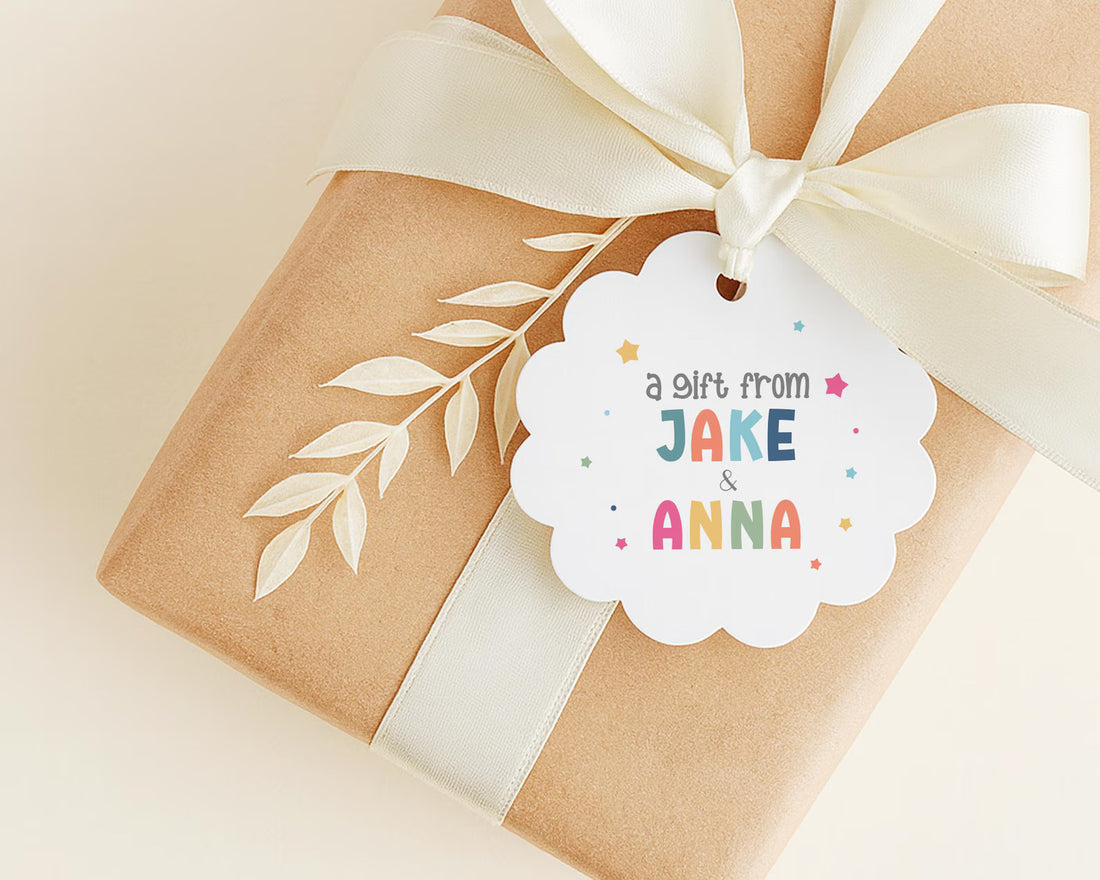 A gift wrapped in brown paper with a white ribbon and a scalloped edge, featuring a white tag with a message that reads "a gift from JANE & ANNA".