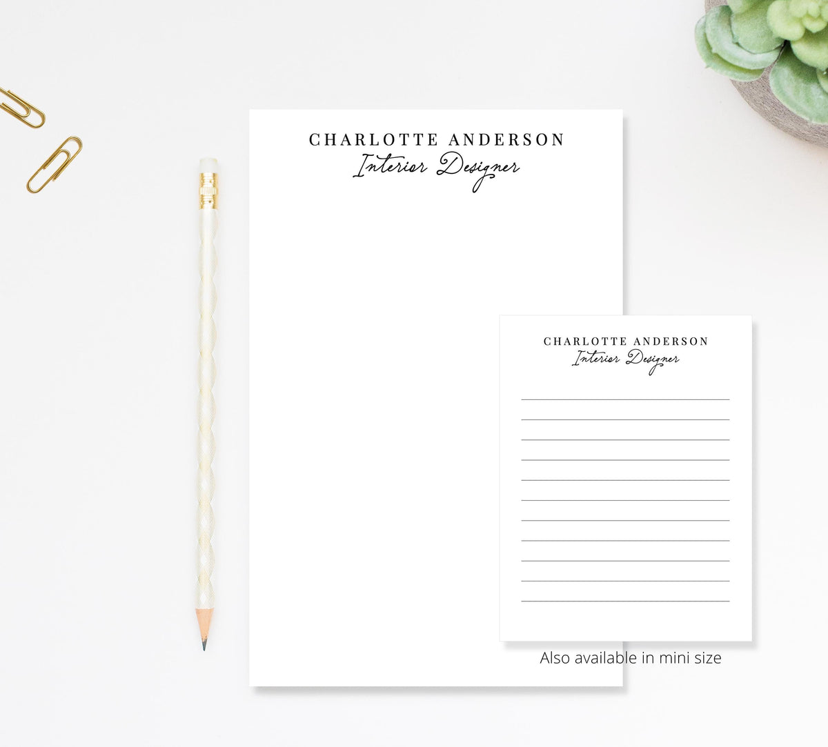 a workspace with a blank name card and a pencil on a white surface.