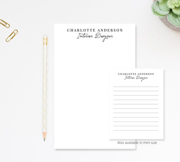 a workspace with a blank name card and a pencil on a white surface.