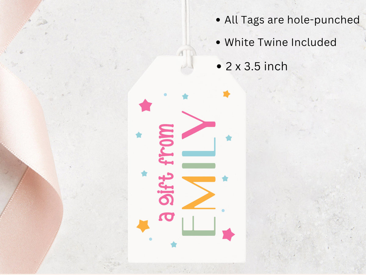 A white gift tag with colorful text and stars hanging from a string.