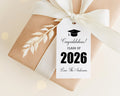 A gift box with a white ribbon and a graduation cap tag attached to it, celebrating the class of 2026.